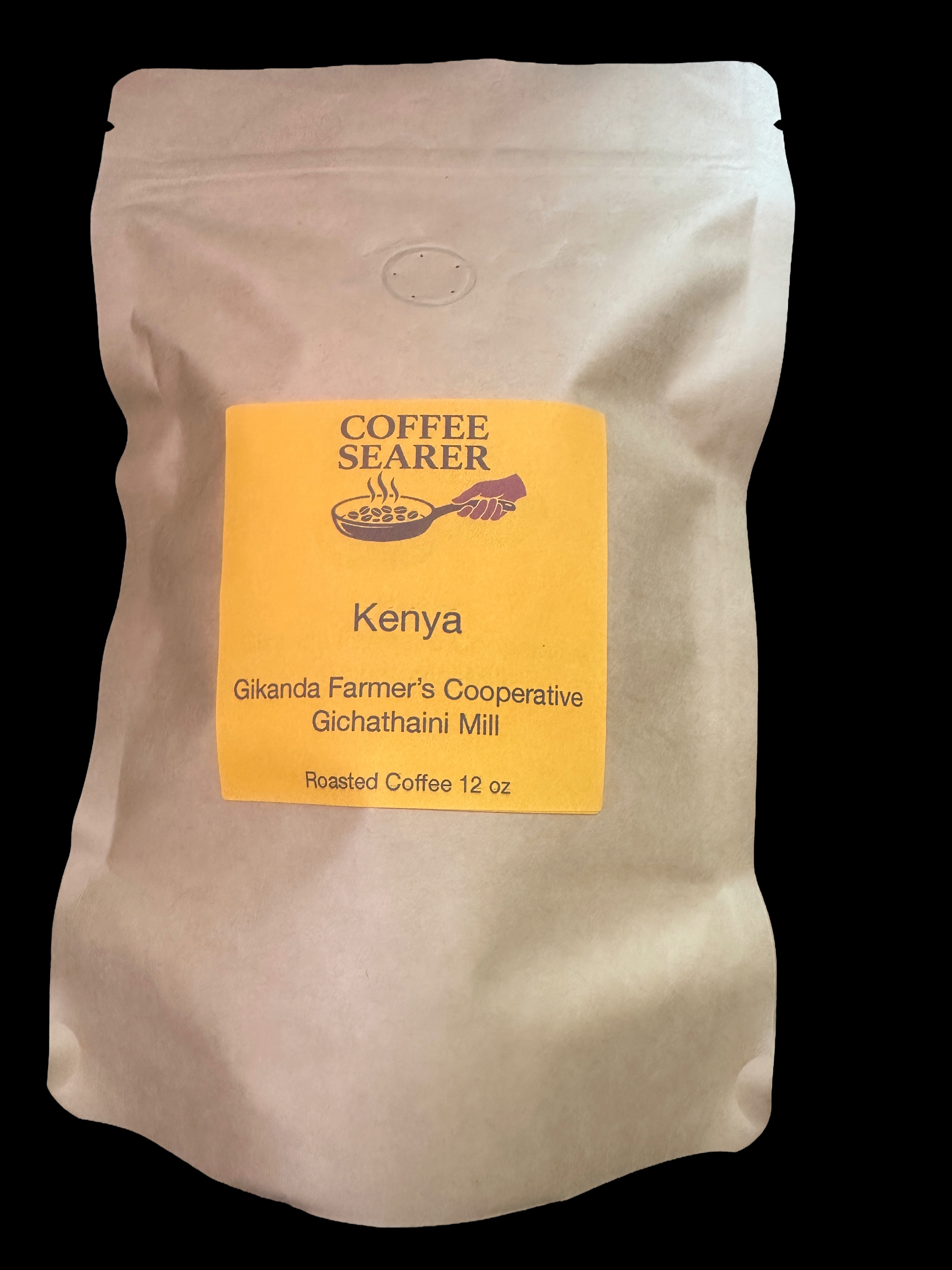 A 12 oz bag of Coffee Searer roasted coffee from Kenya, featuring a cream-colored paper pouch with a bright yellow label on a solid black background.