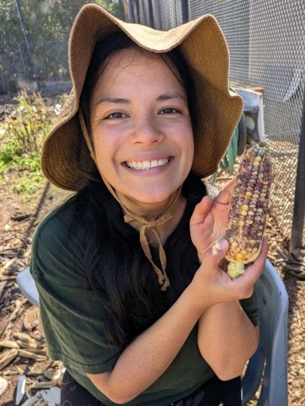 Rumbling Rock co-founder Dr. Ximena sitting on a research farm